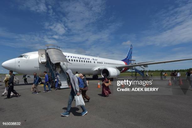 Passengers of a Sriwijaya Air flight disembark from the airplane at the Fatmawati airport in Bengkulu on June 1, 2018. - Sriwijaya Air is an...