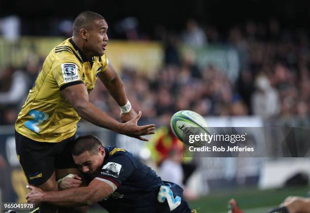 Julian Savea of the Hurricanes off-loads the ball during the round 16 Super Rugby match between the Highlanders and the Hurricanes at Forsyth Barr...