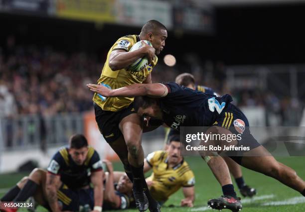 Julian Savea of the Hurricanes is tackled by Daniel Lienert-Brown of the Highlanders during the round 16 Super Rugby match between the Highlanders...