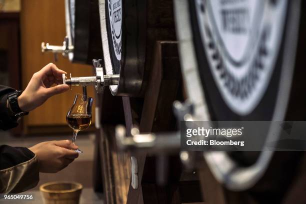 An employee dispense a glass of Kavalan whisky in the tasting room at the Kavalan Single Malt Whisky distillery in Yilan County, Taiwan, on Thursday,...