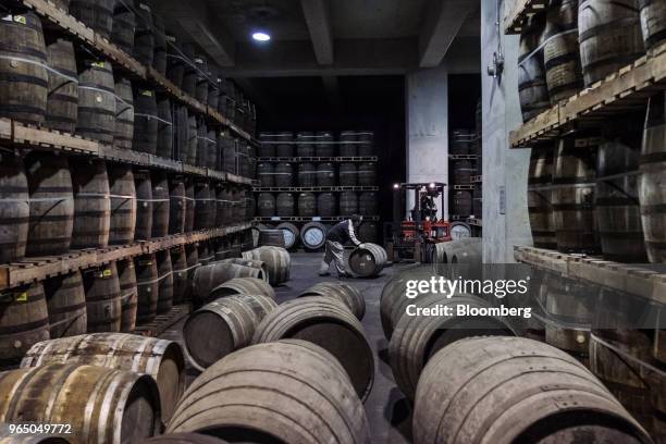 An employee moves a cask in a warehouse at the Kavalan Single Malt Whisky distillery in Yilan County, Taiwan, on Thursday, Jan. 25, 2018. Kavalan is...