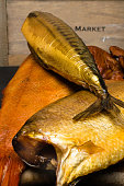 Smoked fish, mackerel, sig, perch and cod roe on the black wooden table. Omega 3 source. Polyunsaturated fats