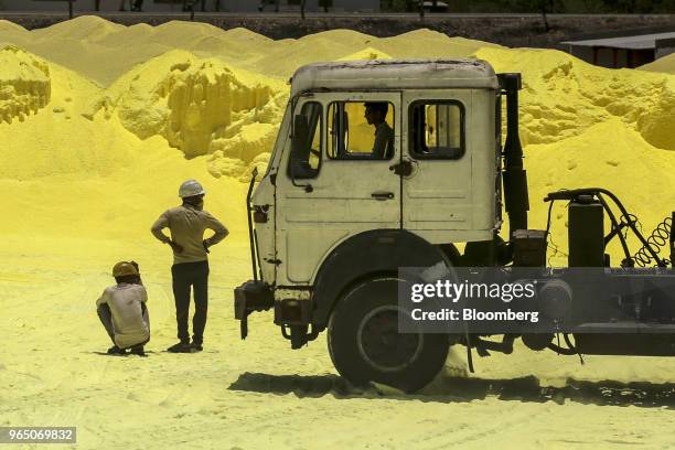 Workers wait as sulfur is loaded into trucks at the Vadinar Refinery complex operated by Nayare Energy Ltd., formerly known as Essar Oil Ltd. And now...