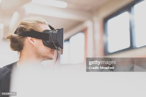 mann mit einer virtual-reality-kopfhörer in eine neue geschäftsstelle - mmeemil stock-fotos und bilder