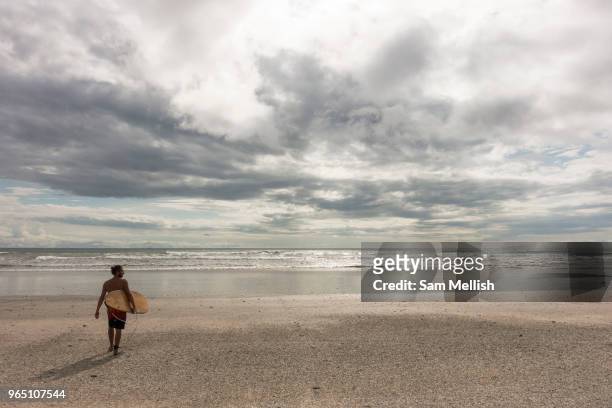 Male surfer walks out to the beach break at Playa Santa Teresa in Malpais on the Nicoya Peninsula on the 9th November 2016 in Costa Rica, Central...