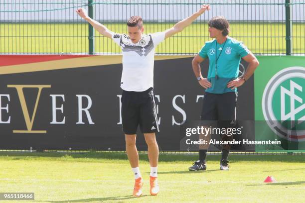 Julian Draxler runs next to Joachim Loew, head coach of the German national team during a training session of the German national team at Sportanlage...