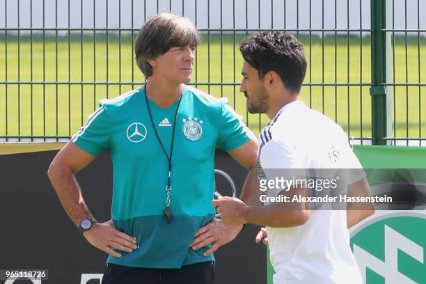 Ilkay Guendogan runs next to Joachim Loew, head coach of the German national team during a training session of the German national team at...