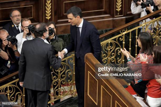 Spanish out-going Prime Minister Mariano Rajoy shakes hands with Spain's new Prime Minister Pedro Sanchez after a vote on a no-confidence motion at...