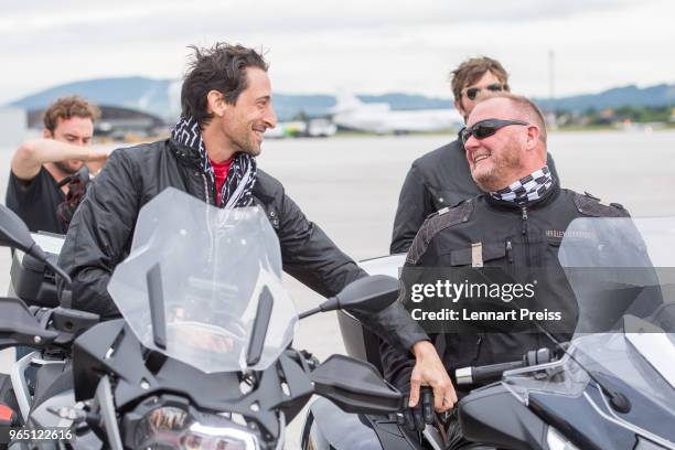 EpicRider Adrien Brody and amfAR CEO Kevin Robert Frost talk to each other during the arrival of the Life Ball plane on June 1, 2018 in Salzburg,...