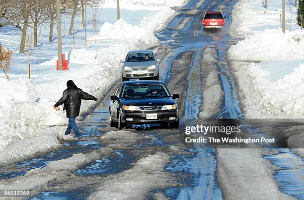 With sidewalks still snowed under, pedistrians and cars share the roadway on Fairview Ave. In Frederick Monday, February 8.