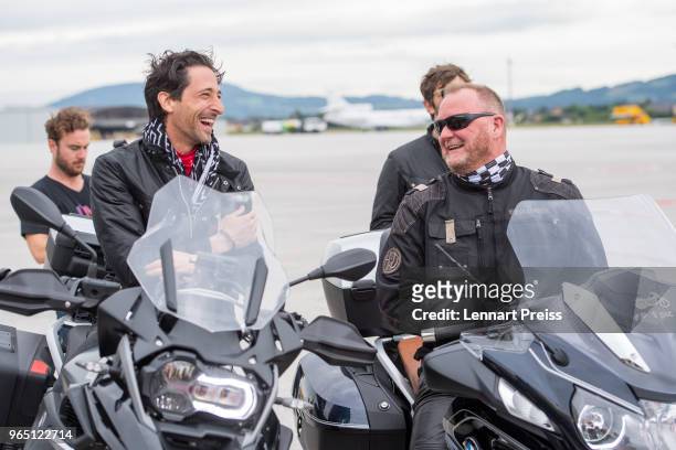 EpicRider Adrien Brody and amfAR CEO Kevin Robert Frost talk to each other during the arrival of the Life Ball plane on June 1, 2018 in Salzburg,...