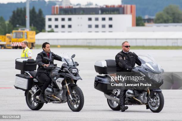 EpicRider Adrien Brody and amfAR CEO Kevin Robert stop their bikes on the apron before the arrival of the Life Ball plane on June 1, 2018 in...