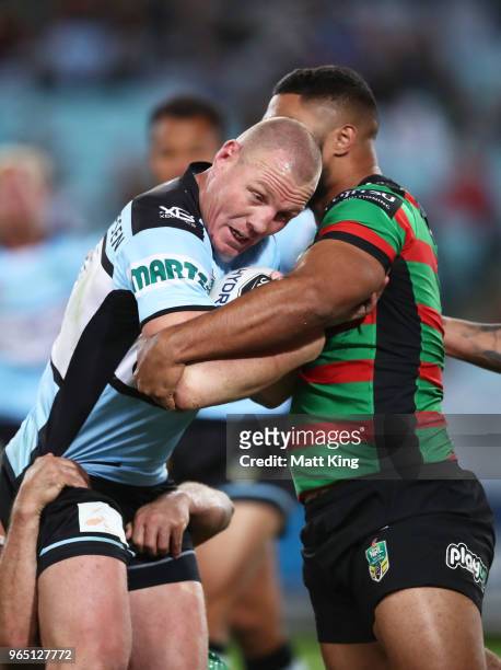 Luke Lewis of the Sharks is tackled during the round 13 NRL match between the South Sydney Rabbitohs and the Cronulla Sharks at ANZ Stadium on June...