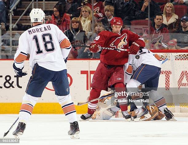 Robert Lang of the Phoenix Coyotes fights for the puck as Ethan Moreau of the Edmonton Oilers watches on February 8, 2010 at Jobing.com Arena in...