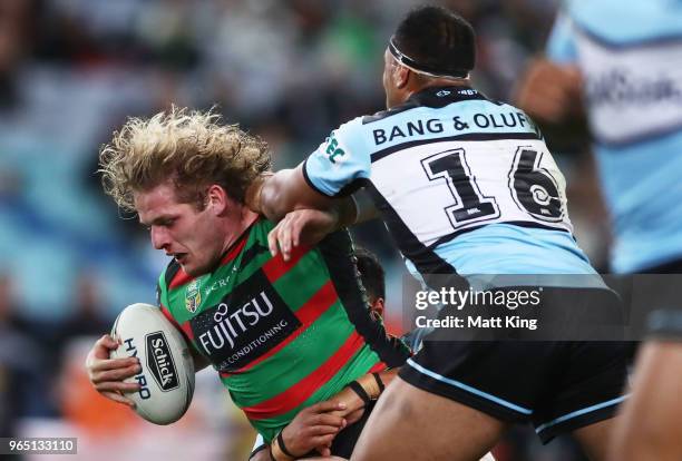 George Burgess of the Rabbitohs is tackled during the round 13 NRL match between the South Sydney Rabbitohs and the Cronulla Sharks at ANZ Stadium on...