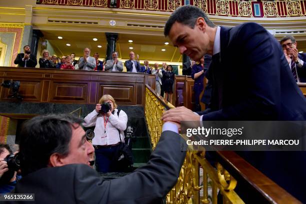 Spain's new Prime Minister Pedro Sanchez is congratulated by Basque Nationalist Party parliamentary spokesman, Aitor Esteban after a vote on a...