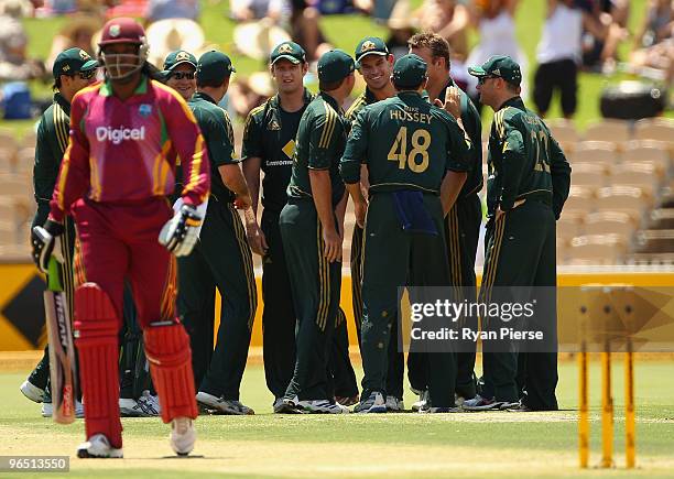 The Australian team look on as Chris Gayle of the West Indies walks from the ground after being dismissed by the first ball of the match by Doug...