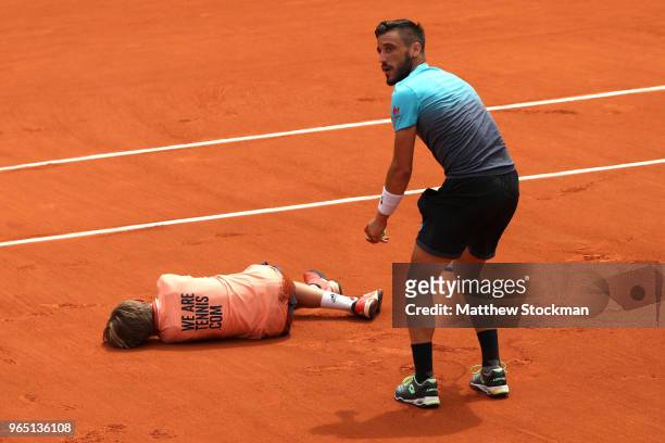Damir Dzumhur of Bosnia and Herzegovinia colides with a ball boy during his mens singles third round match against Alexander Zverev of Germany during...