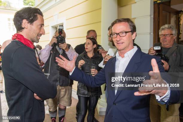 Adrien Brody is welcomed by Thaddaeus Ropac prior to the Thaddaeus Ropac's brunch during the amfAR EpicRide to Life Ball at Villa Emslieb on June 1,...