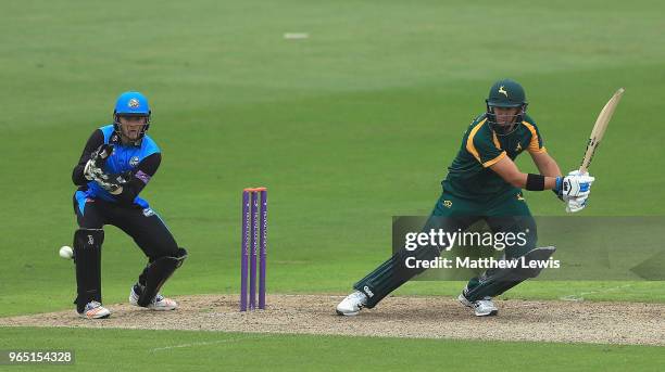 Ross Taylor of Nottinghamshire hits the ball towards the boundary, as Ben Cox of Worcestershire looks on during the Royal London One-Day Cup match...