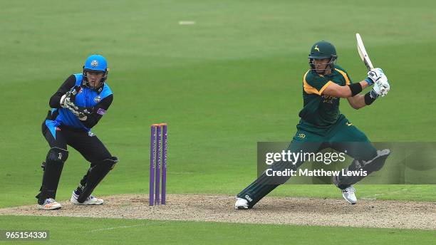 Ross Taylor of Nottinghamshire hits the ball towards the boundary, as Ben Cox of Worcestershire looks on during the Royal London One-Day Cup match...