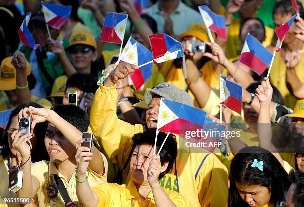 Supporters of Philippine religious leader and presidential candidate Eddie Villanueva wave mini national flags as they attend the campaign opening...