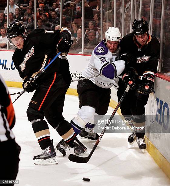 Matt Greene of the Los Angeles Kings battles for the puck against Corey Perry and Kyle Chipchura of the Anaheim Ducks during the game on February 8,...