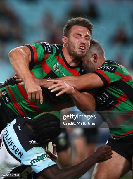 Edrick Lee of the Sharks is tackled over the top by Sam Burgess of the Rabbitohs during the round 13 NRL match between the South Sydney Rabbitohs and...