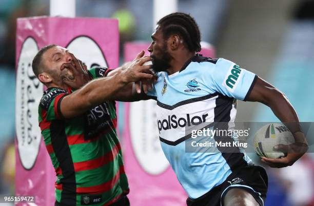 Edrick Lee of the Sharks puts a fend on Robbie Farah of the Rabbitohs during the round 13 NRL match between the South Sydney Rabbitohs and the...