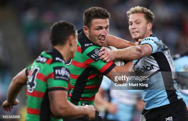 Sam Burgess of the Rabbitohs is tackled during the round 13 NRL match between the South Sydney Rabbitohs and the Cronulla Sharks at ANZ Stadium on...