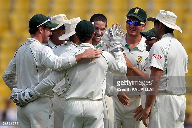 South African cricketer Wayne Parnell celebrates with teammates after taking the wicket of unseen Indian batsman Subramaniam Badrinath on the fourth...