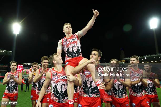Daniel Hannebery of the Swans is chaired from the field by his team mates after his 200th match after the round 11 AFL match between the Sydney Swans...