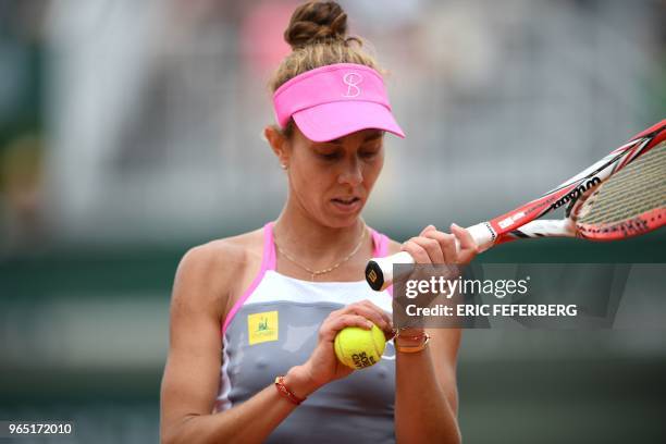 Romania's Mihaela Buzarnescu adjusts her bracelet as she prepares to serve to Ukraine's Elina Svitolina during their women's singles third round...