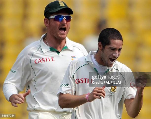 South African cricket captain Graeme Smith celebrates with teammate Wayne Parnell after the dismissal of Indian batsman Subramaniam Badrinath on the...