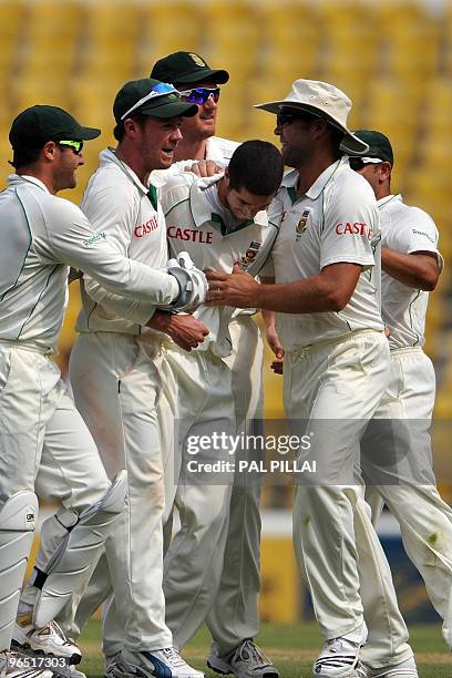 South African cricketer Wayne Parnell is congratulated by his teammates as they celebrate the dismissal of Indian batsman Subramaniam Badrinath on...