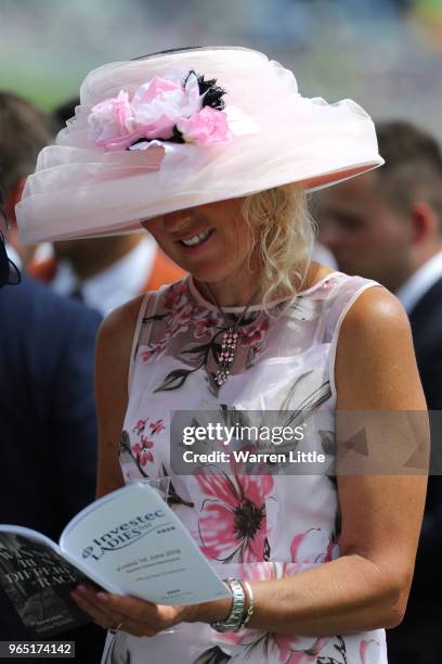 Racegoers read the official race programme during Ladies Day of the Investec Derby Festival at Epsom Downs on June 1, 2018 in Epsom, England.