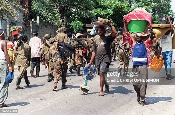 Looters meet with Laurent Desire Kabila's Alliance rebel troops entering Kinshasa, 18 May 1997, at Tshatshi camp. In October 1996, Zairean opposition...