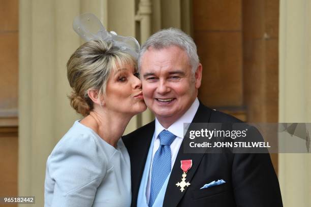 Journalist and broadcaster, Eamonn Holmes, , with his wife Ruth Langsford, poses with his medal after he was appointed Officer of the Order of the...