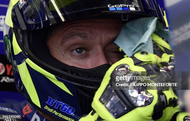 Movistar Yamaha's Italian rider Valentino Rossi wipes his face as he sits in the box during a free practice session ahead of the Italian MotoGP Grand...