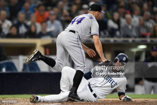 Joey Luchessi of the San Diego Padres is tagged out at home plate by Tyller Anderson of the Colorado Rockies during the game at PETCO Park on May 14,...