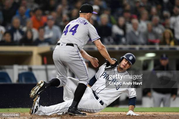 Joey Luchessi of the San Diego Padres is tagged out at home plate by Tyller Anderson of the Colorado Rockies during the game at PETCO Park on May 14,...