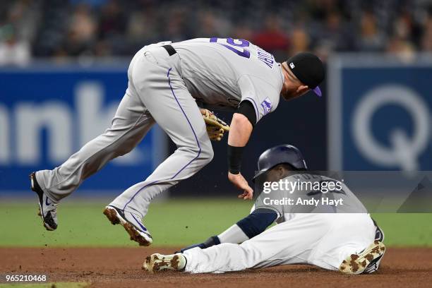 Franchy Cordero of the San Diego Padres steals second base as Trevor Story of the Colorado Rockies attempts a tag at second base during the game at...