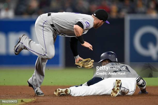 Franchy Cordero of the San Diego Padres steals second base as Trevor Story of the Colorado Rockies attempts a tag at second base during the game at...