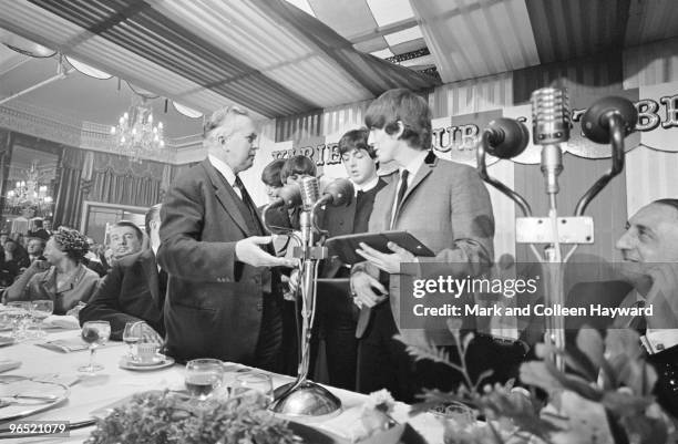 George Harrison of the Beatles accepts his award from British Labour Leader of the Opposition Harold Wilson at the Variety Club of Great Britain...