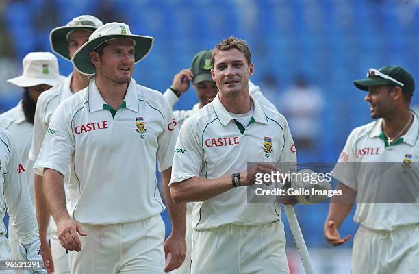 Graeme Smith and Dale Steyn of South Africa smile as they walk off after winning by an innings and 6 runs during day 4 of the 1st test between India...