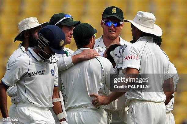 Indian cricketer S.Badrinath leaves the pitch after losing his wicket as South African captain Graeme smith celebrates with teammates on the fourth...
