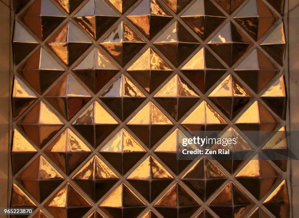 metal and concrete designed to create geometric shapes on a wall of an old building - pyramide geometrische form stock-fotos und bilder
