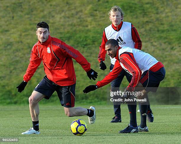 Albert Riera goes past David Ngog as Dirk Kuyt looks on during a team training session at the club's Melwood training ground on February 9, 2010 in...