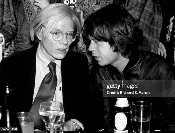 Andy Warhol talks to Mick Jagger from The Rolling Stones at a party in New York in 1977