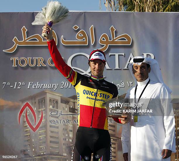 Quickstep team rider Tom Boonen of Belgium receives his trophy from Qatar Cycling Federation official Ahmed al-Hamidi after winning the third stage...